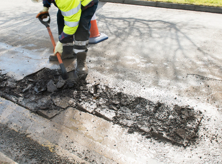 road worker creating breaks on the part of the road that needs repairs
