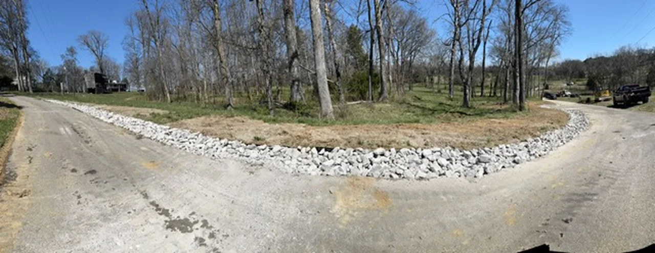 Rock-lined drainage channel beside a gravel drive in Middle Tennessee